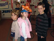 Two students are placed back to back. One student is slightly taller. A third student observes them.